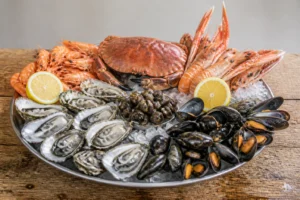 Plateau de fruits de mer avec coquillages et crustacés : huîtres, moules, crevettes, crabe et langoustines sur glace