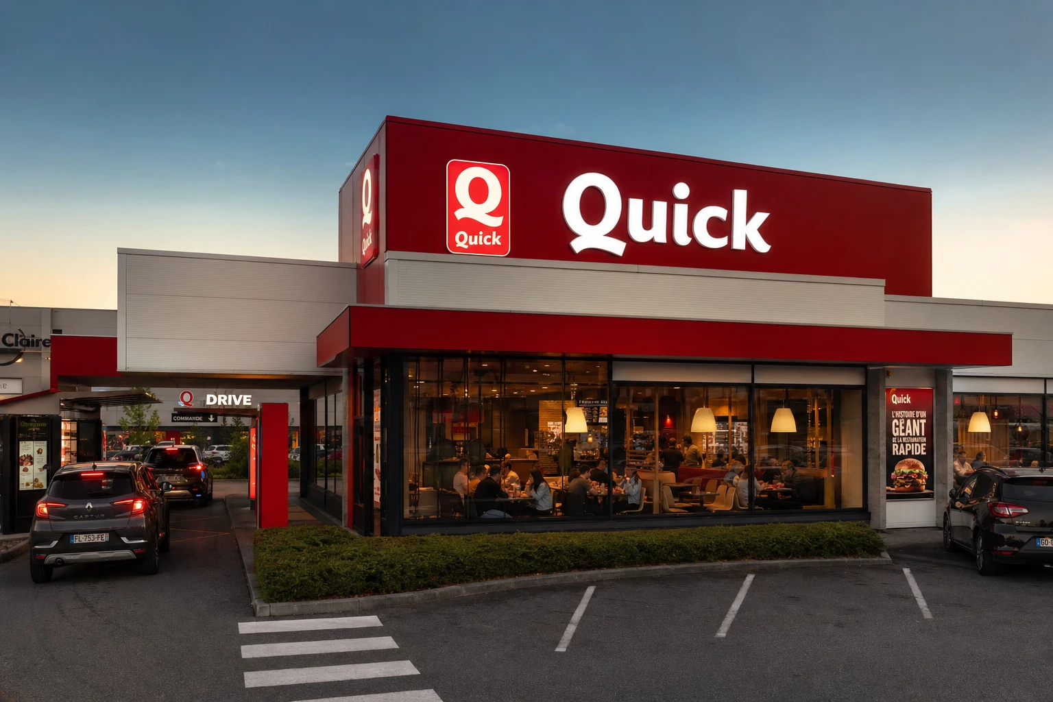 Façade d'un restaurant Quick halal avec enseigne lumineuse et drive en France